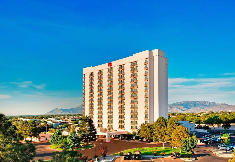 Sheraton Albuquerque Airport Hotel tower, landscaped grounds and mountain backdrop